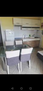a kitchen with a glass table and two chairs at Apartment Sunset in Šibenik