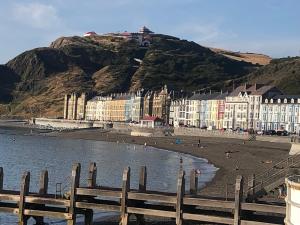 a group of buildings on a beach next to the water at Cosy holiday caravan minutes from the beach in Aberystwyth