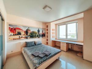 1 dormitorio con 1 cama y una pintura en la pared en Cozy apartments on the Left Bank en Kiev