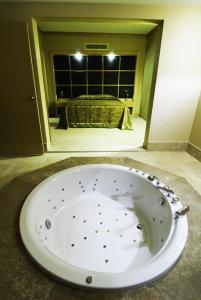 古雷阿德林娜特马尔健康温泉酒店的配有床铺的客房内的白色浴缸