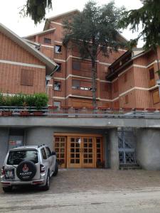 un coche aparcado en un aparcamiento frente a un edificio en Residence I Comignoli, en Scanno