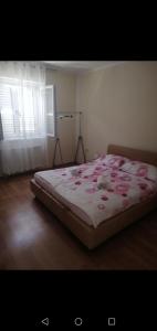 um quarto com uma cama com flores cor-de-rosa em Apartment Sunset em Sibenik