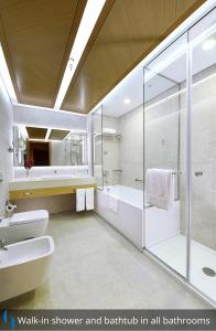 a bathroom with a shower and a sink and a bath tub at Grand Cosmopolitan Hotel in Dubai
