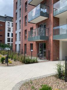 a brick building with a balcony on the side at Uroczy apartament nad Motławą, miejsce parkingowe w strzeżonej hali in Gdańsk