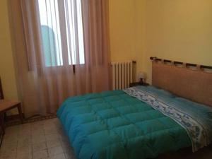 a bedroom with a bed with a blue blanket on it at Villa Puccini in Montecatini Terme +14 photos
