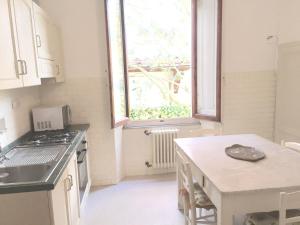 una cucina con lavandino, tavolo e finestra di Villa Puccini a Montecatini Terme