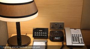 a desk with a lamp and a telephone and a phone at Grand Cosmopolitan Hotel in Dubai