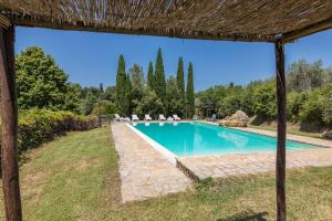 una piscina en un patio con sillas y árboles en Casale Presciano, en Pergine Valdarno