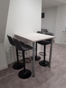 una mesa blanca con cuatro sillas alrededor en Appartement centre ville, en Moulins