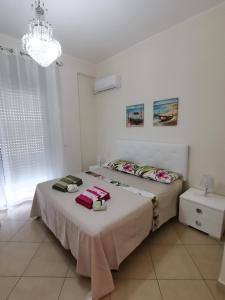 a bedroom with a bed and a chandelier at Appartamento Relax in centro in Capo dʼOrlando