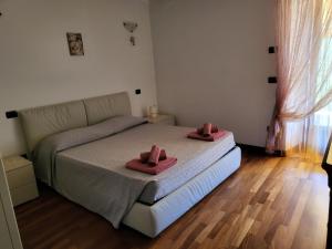 a bedroom with a bed with pink towels on it at Appartamento Gobi in Castel Condino