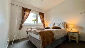 sypialnia z dużym łóżkiem i oknem w obiekcie Old Captain Guest House w mieście Portree