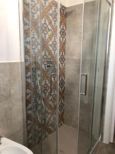 a shower with a glass door in a bathroom at Le maioliche allo Stagnone kite in Marsala +38 photos