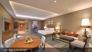 a hotel room with a bed and a living room at Grand Cosmopolitan Hotel in Dubai