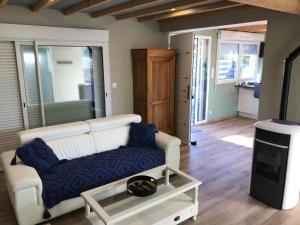 a living room with a couch and a tv at Gîte spa sauna piscine in Aubin-Saint-Vaast