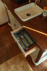 an open drawer under a sink in a kitchen at Glamping in Wiltshire in our luxury Shepherds Hut in Chippenham