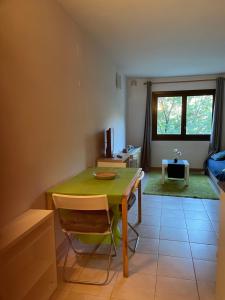 a dining room with a green table and a couch at Sol i Neu in Encamp