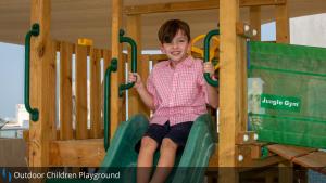 a young boy sitting on a slide at a playground at Grand Cosmopolitan Hotel in Dubai