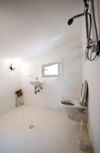a white bathroom with a toilet and a sink at Jabia Beach House in Marinella di Selinunte