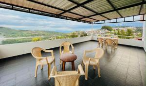 a balcony with chairs and a table with a view at M town Homestay in Kodaikānāl