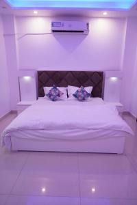 Una cama blanca con dos almohadas encima. en Own Stay, en Nueva Delhi