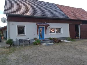 a house with a blue door and a porch at Ferienwohnung Bittner in Klitten