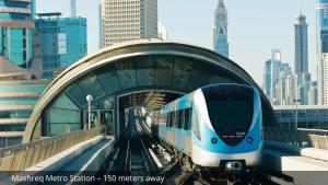 a blue and white train traveling under a bridge at Grand Cosmopolitan Hotel in Dubai