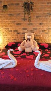 a teddy bear sitting on a bed with a book at Hotel Riojano in Humanes de Madrid