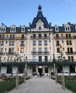 a large yellow building with a black roof at Studio 329 in Aix-les-Bains