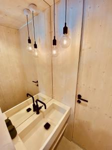 uma casa de banho com um lavatório e um chuveiro em BUQEZ ECO RESORT - Beach Villa 28 - Directly by beach em Drage