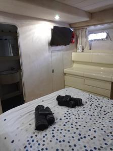 un paio di pantofole su un letto in un camper di Un yacht de 24m rien que pour vous ! a Sète