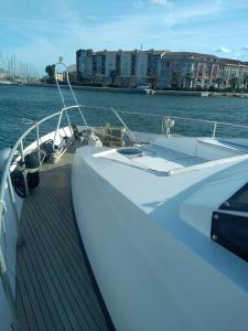 a white boat on the water with buildings in the background at Un yacht de 24m rien que pour vous ! in Sète