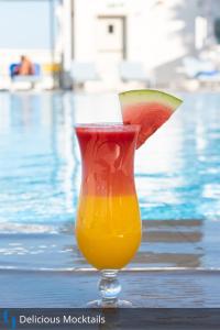 a vase with a slice of watermelon in it next to a pool at Grand Cosmopolitan Hotel in Dubai