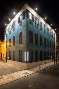 niebiesko-biały budynek na ulicy w nocy w obiekcie Alcântara Factory II w Lizbonie