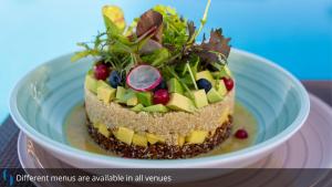 a cake with fruit on top of it on a plate at Grand Cosmopolitan Hotel in Dubai