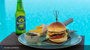 a sandwich on a plate next to a bottle of beer at Grand Cosmopolitan Hotel in Dubai
