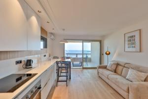 a kitchen and living room with a couch and a table at CENTER BAY in Juan-les-Pins
