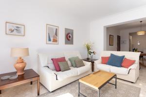 ein Wohnzimmer mit zwei weißen Sofas und einem Tisch in der Unterkunft Marina 8 - Vivienda vacacional en el corazón del Puerto De la Cruz in Puerto de la Cruz + 33 Fotos
