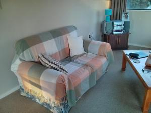 a living room with a couch and a tv at Gateway to Abel Tasman Park & Kaiteriteri. 