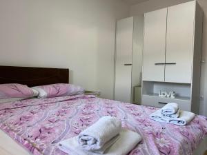 1 dormitorio con 1 cama con toallas en Apartman Ano LUX en Novi Pazar