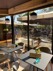 a restaurant with two tables and chairs and umbrellas at Alevic Hotel Sirmione in Sirmione