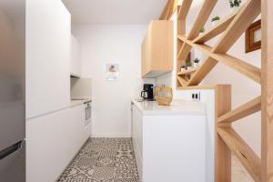 eine Küche mit weißen Theken und Holzdecken in der Unterkunft Marina 8 - Vivienda vacacional en el corazón del Puerto De la Cruz in Puerto de la Cruz