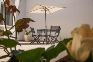 uma mesa e cadeiras e um guarda-sol num quarto em La Volta - Casa Vacanze em Galatina