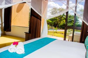 a bedroom with a bed with towels and a window at Wild View Resort in Kasane