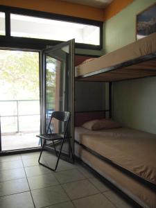 Un dormitorio con literas y una silla. en Summit Zero Hostel en Plaka Litochorou