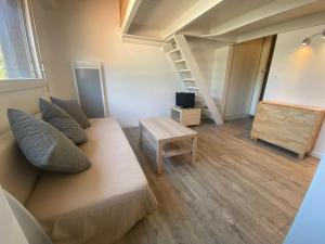 a living room with a couch and a stair case at Ferret vacances in Lège-Cap-Ferret