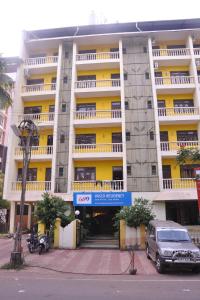 a white and yellow building with a car parked in front at Vasco Residency in Vasco Da Gama