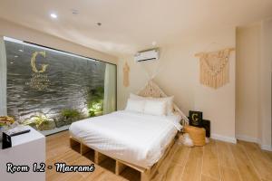 1 dormitorio con cama blanca y ventana grande en Galaxy Hotel 2 en Ho Chi Minh