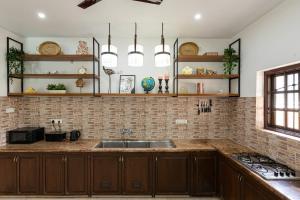 a kitchen with wooden cabinets and a sink at Villa Calangute Phase 5 in Calangute