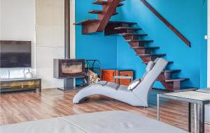 a living room with a blue wall and a staircase at Beautiful Home In Nowe Warpno With Wifi in Nowe Warpno